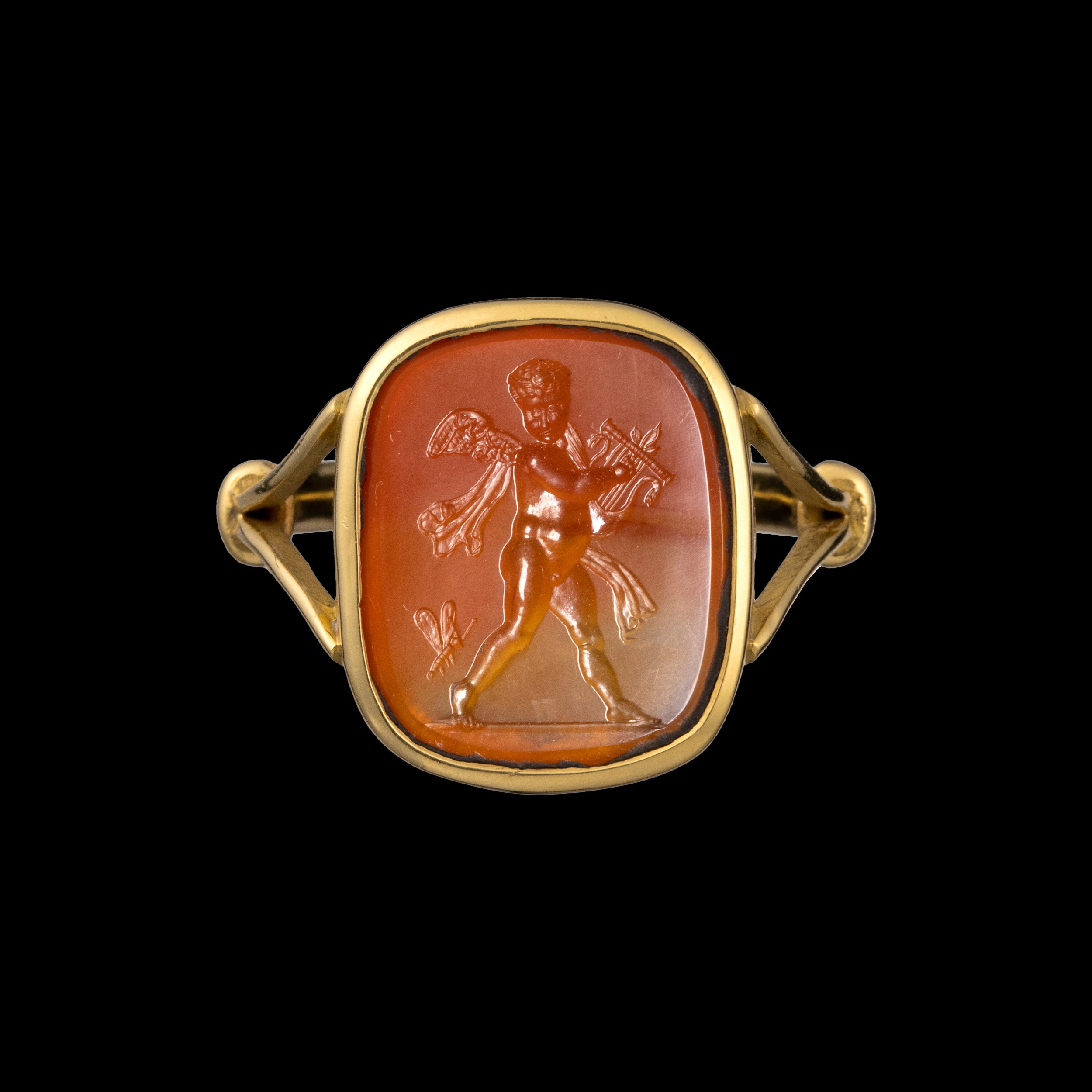 A gold ring set with a Neoclassical agate intaglio. Cupid playing the lyra with butterfly. 
